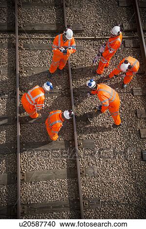 Stock Image - Railway workers examining train tracks. Fotosearch