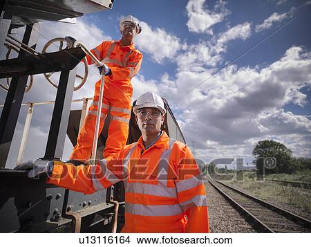 Picture - Railway workers standing on train. Fotosearch