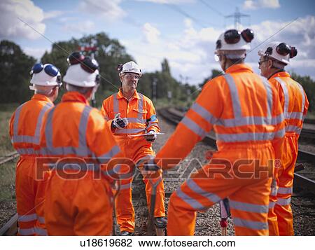Stock Image - Railway workers talking on train tracks. Fotosearch