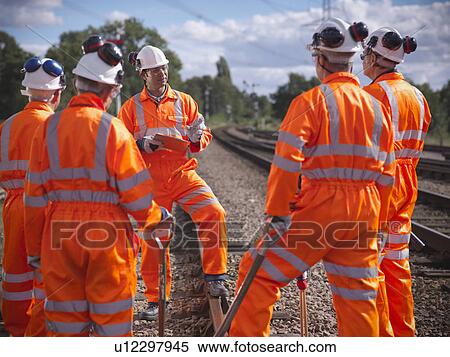 Railway workers talking on train tracks View Large Photo Image Stock Photography - Railway workers talking on train tracks. Fotosearch