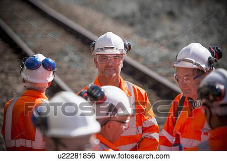 Railway workers talking outdoors View Large Photo Image Stock Photograph - Railway workers talking outdoors. Fotosearch