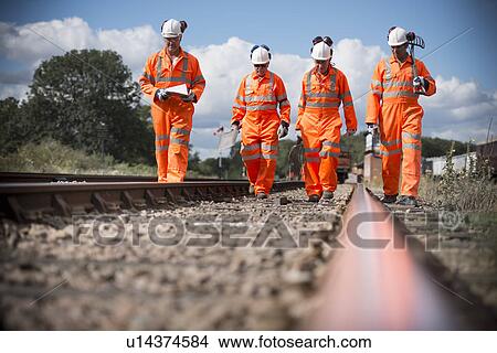 Railway workers walking on train tracks View Large Photo Image Picture - Railway workers walking on train tracks. Fotosearch