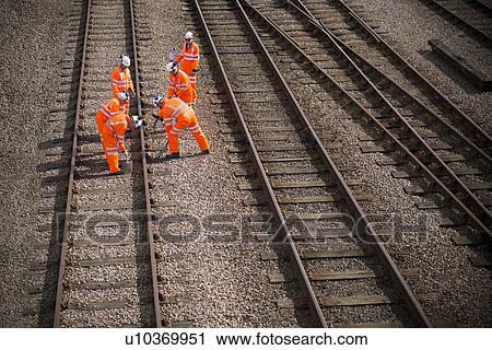 Railway workers walking on train tracks View Large Photo Image Stock Image - Railway workers walking on train tracks. Fotosearch