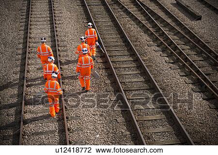 Railway workers walking on train tracks View Large Photo Image Stock Image - Railway workers walking on train tracks. Fotosearch