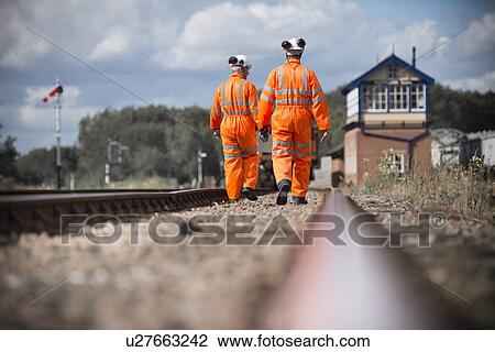 Railway workers walking on train tracks View Large Photo Image Stock Image - Railway workers walking on train tracks. Fotosearch