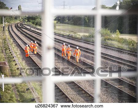 Stock Photo - Railway workers walking on train tracks. Fotosearch