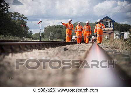 Stock Photograph - Railway workers walking on train tracks. Fotosearch