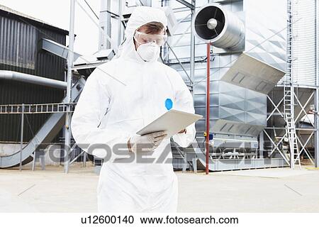 Stock Image - Scientist writing on clipboard. Fotosearch
