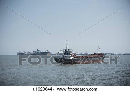Ship sailing in urban harbor View Large Photo Image Stock Photo - Ship sailing in urban harbor. Fotosearch