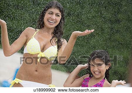 Sisters playing in water outdoors View Large Photo Image Stock Image - Sisters playing in water outdoors. Fotosearch