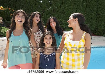 Stock Photograph - Sisters smiling together by pool. Fotosearch