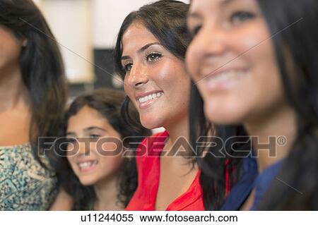 Stock Photography - Sisters smiling together in kitchen. Fotosearch
