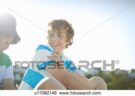 Stock Photograph - Smiling boys sitting outdoors. Fotosearch