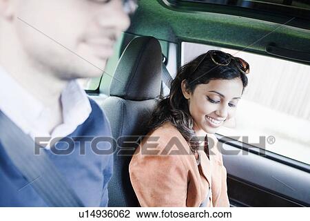 Stock Image - Smiling couple riding in car. Fotosearch