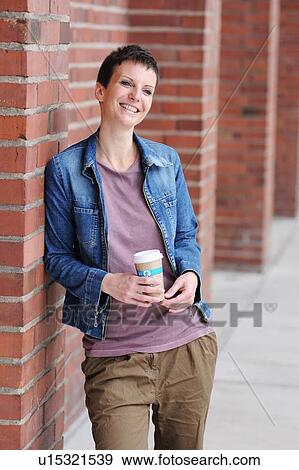 Stock Photo - Smiling woman holding cup of coffee. Fotosearch