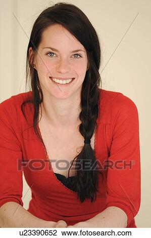 Stock Image - Smiling woman leaning on table. Fotosearch