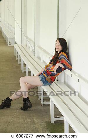 Stock Photo - Smiling woman sitting on bench. Fotosearch