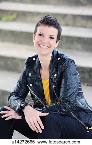 Smiling woman sitting on city steps View Large Photo Image Stock Photograph - Smiling woman sitting on city steps. Fotosearch