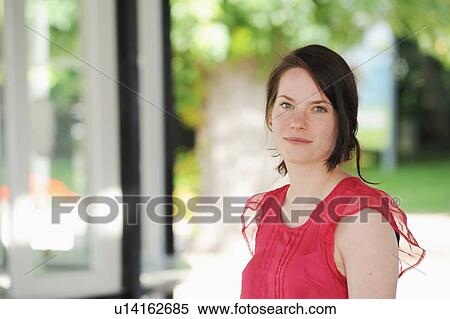 Stock Photography - Smiling woman standing indoors. Fotosearch