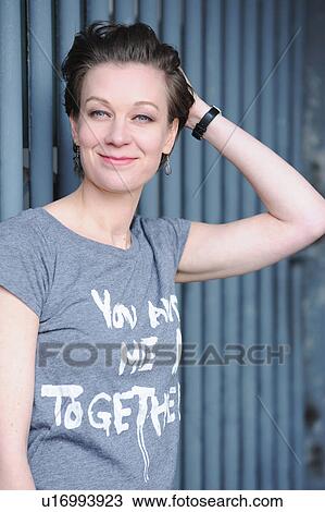 Stock Image - Smiling woman standing outdoors. Fotosearch
