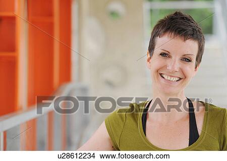 Picture - Smiling woman walking on city street. Fotosearch