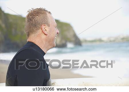 Surfer wearing wet suit on beach View Large Photo Image Stock Photograph - Surfer wearing wet suit on beach. Fotosearch