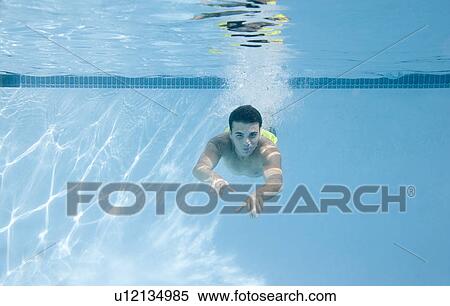 Stock Photography - Teenage boy swimming underwater. Fotosearch