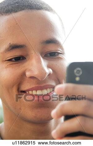 Stock Photography - Teenage boy using cell phone outdoors. Fotosearch