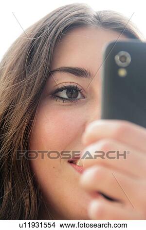 Picture - Teenage girl using cell phone outdoors. Fotosearch