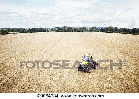 Tractor driving in tilled crop field View Large Photo Image Picture - Tractor driving in tilled crop field. Fotosearch