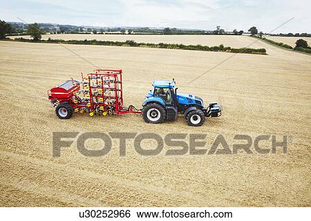 Tractor driving in tilled crop field View Large Photo Image Stock Photograph - Tractor driving in tilled crop field. Fotosearch