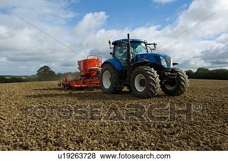 Tractor working in crop field View Large Photo Image Stock Photo - Tractor working in crop field. Fotosearch