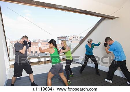 Stock Photo - Trainers working with boxers in gym. Fotosearch