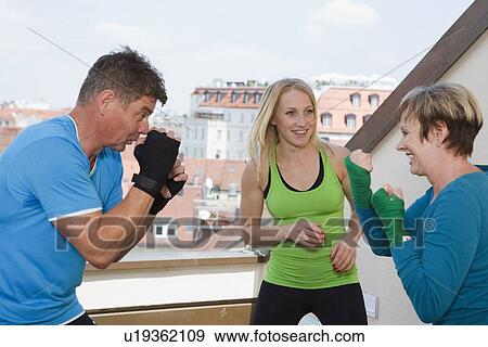 Stock Photo - Trainers working with boxers in gym. Fotosearch