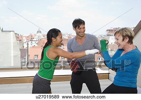 Stock Photo - Trainers working with boxers in gym. Fotosearch