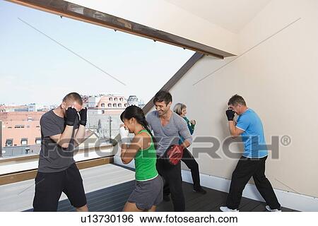 Stock Photograph - Trainers working with boxers in gym. Fotosearch