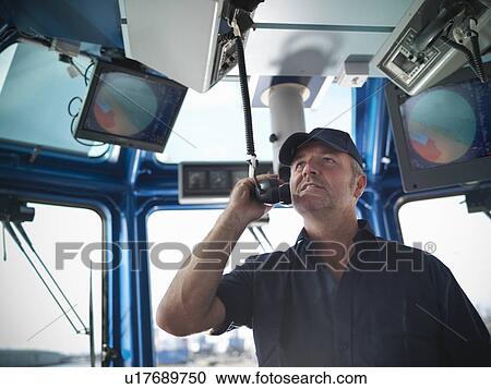 Tugboat captain working in wheelhouse View Large Photo Image Stock Image - Tugboat captain working in wheelhouse. Fotosearch