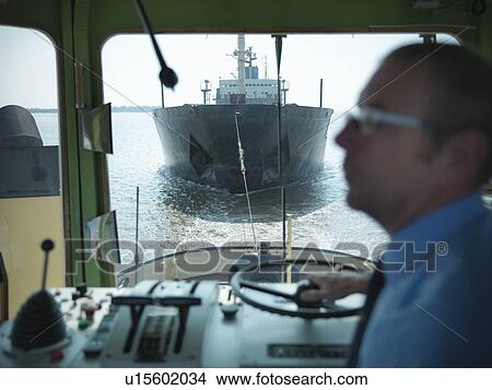 Picture - Tugboat pulling ship in ocean. Fotosearch