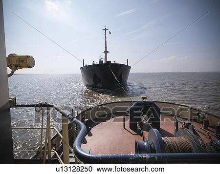 Tugboat pulling ship in ocean View Large Photo Image Stock Image - Tugboat pulling ship in ocean. Fotosearch