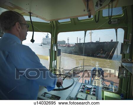 Stock Photography - Tugboat pulling ship in ocean. Fotosearch