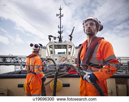 Tugboat worker holding rope on deck View Large Photo Image Stock Image - Tugboat worker holding rope on deck. Fotosearch