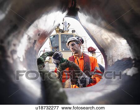 Tugboat worker pulling rope on deck View Large Photo Image Stock Photo - Tugboat worker pulling rope on deck. Fotosearch