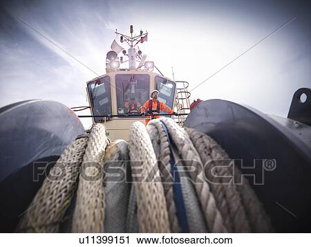 Tugboat worker standing on bridge View Large Photo Image Stock Image - Tugboat worker standing on bridge. Fotosearch