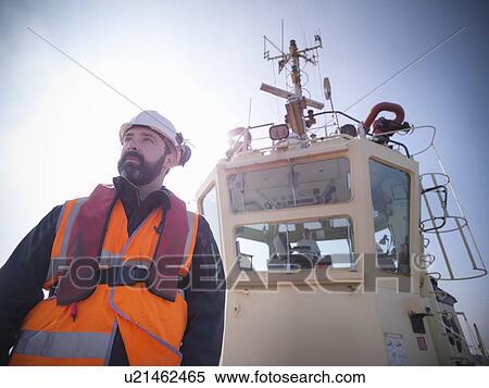 Tugboat worker standing on deck View Large Photo Image Stock Photography - Tugboat worker standing on deck. Fotosearch