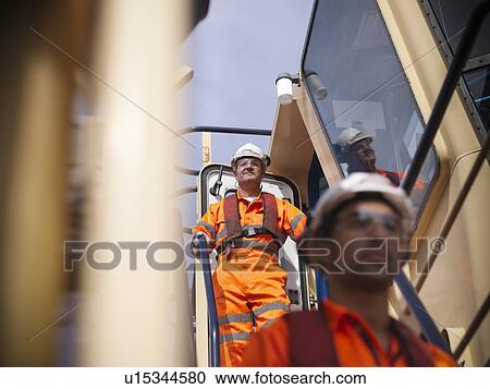 Tugboat workers standing on bridge View Large Photo Image Stock Image - Tugboat workers standing on bridge. Fotosearch