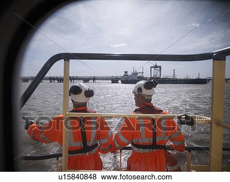Stock Photo - Tugboat workers standing on deck. Fotosearch