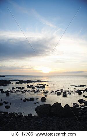 Stock Photograph - Water washing up on rocky beach. Fotosearch