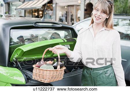 Stock Photo - Woman carrying basket of vegetables. Fotosearch