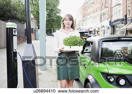 Woman carrying flowerbox on city street View Large Photo Image Stock Image - Woman carrying flowerbox on city street. Fotosearch