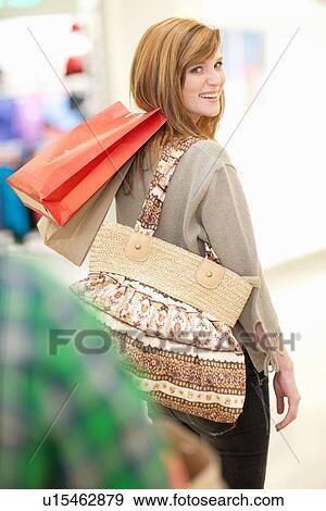 Woman carrying shopping bags in mall View Large Photo Image Stock Photo - Woman carrying shopping bags in mall. Fotosearch